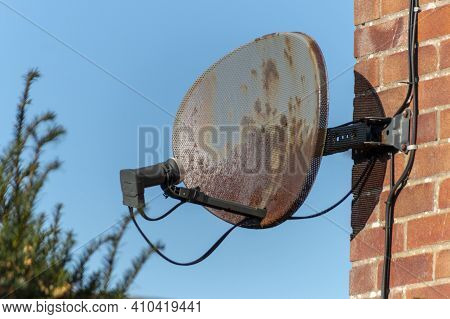 A Close Up View Of A Old Rusted Satellite Dish Attached To A Brick Wall
