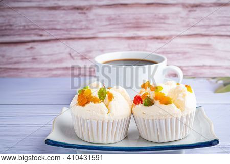 Side View Of Thai Steamed Cupcakes Topped With Dry Fruit On A Plate And A White Coffee Cup With Wood