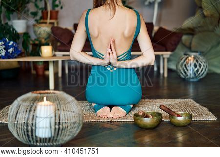 Back View Of Young Woman Practicing Yoga Doing Reverse Prayer Pose At Home. Wellness And Healthy Lif