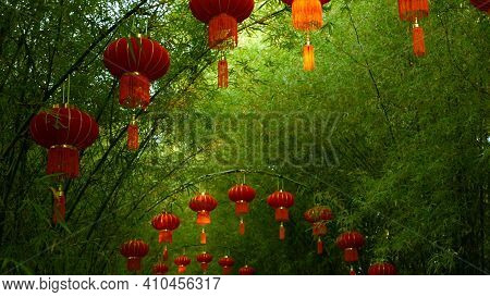 Rows Of Traditional Chinese Style Red Lanterns Hanging On Bamboo Tree Tunnel Arch.