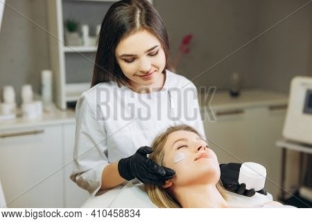 Cosmetologist Applying Cream Essence Essential Vitamins Into Face To Improve Client Skin. Beauty Exp