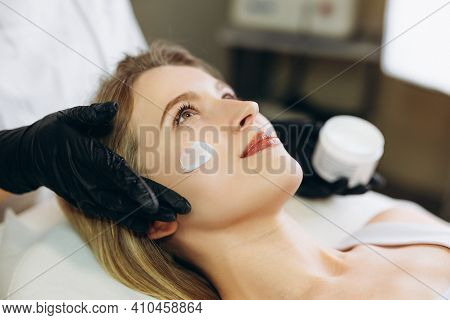 Cosmetologist Applying Cream Essence Essential Vitamins Into Face To Improve Client Skin. Beauty Exp
