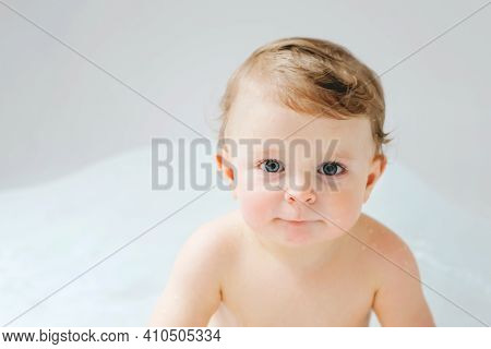 Cute Adorable Baby Child Taking Bath In Bathtub At Home. Happy Healthy Boy Or Girl Playing, Splashin