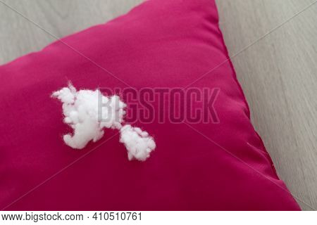 A Lump Of Pillow Filler Lies On A Red Cushion On A Light Wooden Table. Close-up. Selective Focus, Ho