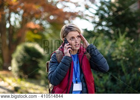 Woman Caregiver, Nurse Or Healthcare Worker Outdoors On The Way To Work, Using Smartphone.