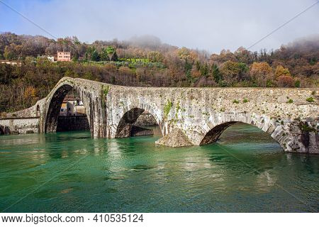 Devil's Bridge over the Cercchio River. Medieval bridge with magnificent architecture. Italy. Province of Tuscany. Outskirts of Bagni di Lucca