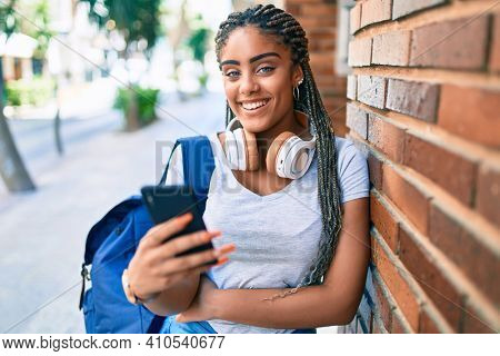 Young african american student woman smiling happy using smartphone at the university campus
