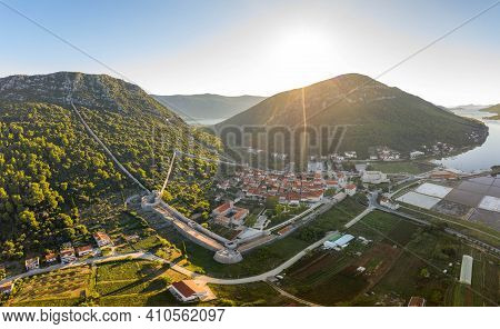 Aerial Drone Shot Of Ston City Wall Over Hill In Ragusa Region Near Dubrovnik In Croatia Summer Sunr