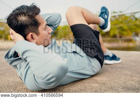 Young Sportsman Doing Cyling Crunches In Park.