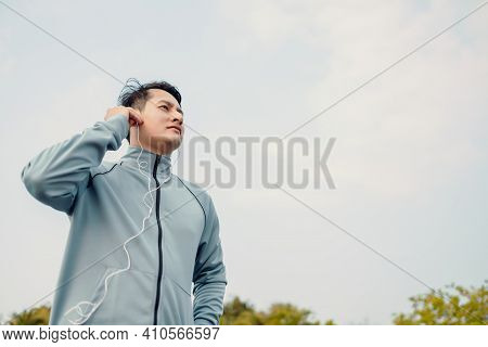 Young Sport Man Jogging And Listening Music In The Park.