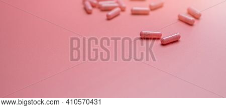 Pink Capsules Pill Spread On Pink Background. Vitamins And Supplements For Healthy Skin, Collagen Bo