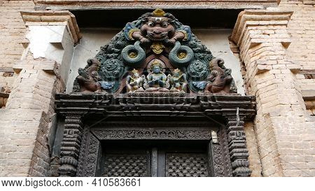Ornamental Design, Temple Entrance. From Below Aged Entrance With Colorful Wooden Old Sculpture Of G