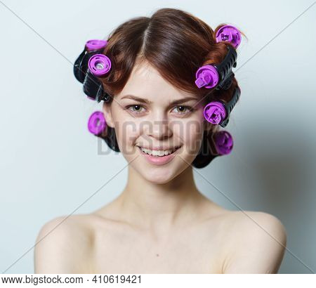Young Woman With Purple Curlers On Her Head Naked Shoulders Gray Background