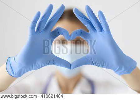 Doctor In Protective Mask Showing Heart With His Hands Closeup. Heart Complications After Covid19 Co