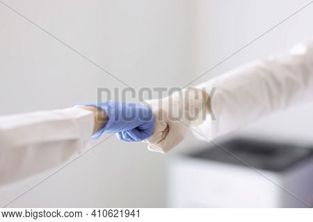 Doctors In Rubber Gloves Touching Each Others Fists Closeup. Medical Teamwork Concept