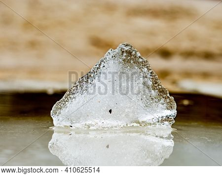 Melting Ice Of Frozen Muddy Water. Light Brown And Pink Ice, Sun Reflections.