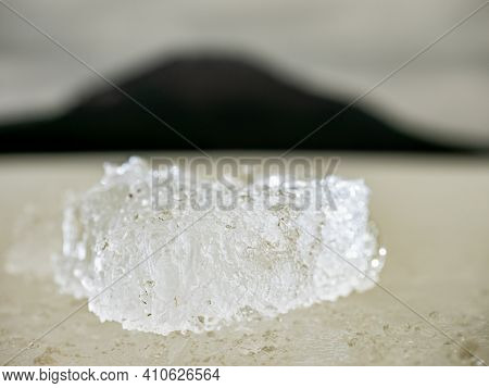 Brightened Piece Of Ice. The Structure Of Radiant Ice Broken Off From The Cover Of The Dam, The Dark