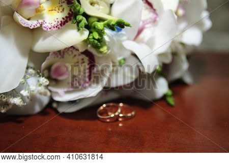 Two Wedding Rings With Orchids Close Up