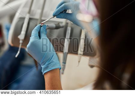 Dentist Smearing Prophy Paste On Handpiece With Dental Instrument