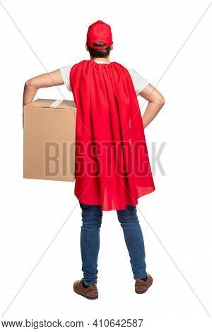 Full Body Back View Of Male Courier In Red Cap And Cape Carrying Big Cardboard Box While Delivering 