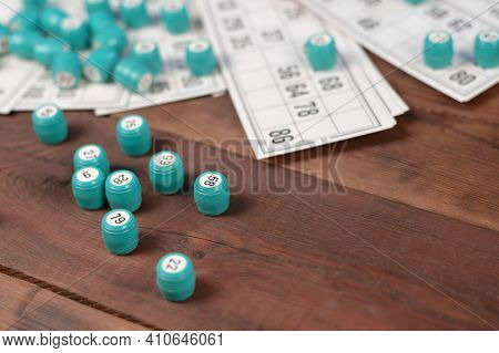 Many Barrels With Numbers And Cards For Lotto Or Russian Bingo Table Game On Wooden Surface. Russian