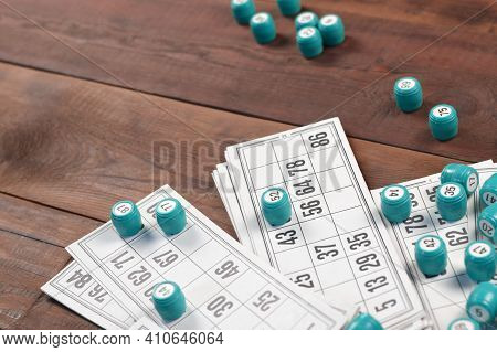 Many Barrels With Numbers And Cards For Lotto Or Russian Bingo Table Game On Wooden Surface. Russian