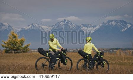 The Man And Woman Travel On Mixed Terrain Cycle Touring With Bikepacking. The Two People Journey Wit