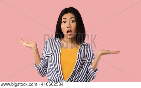 Who Knows. Portrait Of Funny Young Asian Woman Shrugging Shoulders Looking At Camera Posing Over Pin