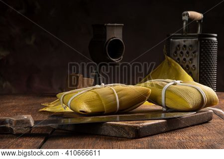 Pamonha, Brazilian Corn Food, Called Pamonha. On A Rustic Table With Knife And Old Corn Grater, Low