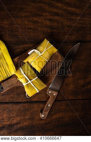 Pamonha, Brazilian Corn Food, Called Pamonha. On A Rustic Table With Knife, Low Key Portrait, Dark A