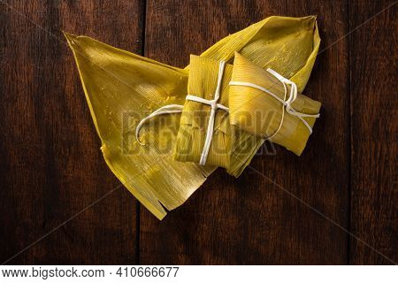 Pamonha, Brazilian Corn Food, Called Pamonha. On A Rustic Table With Knife, Low Key Portrait, Dark A