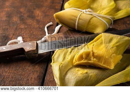 Pamonha, Brazilian Corn Food, Called Pamonha. On A Rustic Table With Knife And Old Corn Grater, Low
