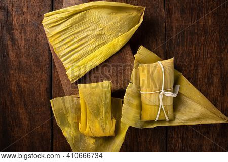 Pamonha, Brazilian Corn Food, Called Pamonha. On A Rustic Table With Knife, Low Key Portrait, Dark A