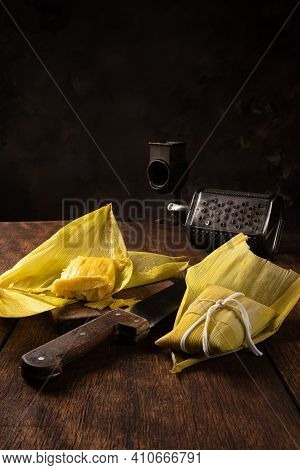 Pamonha, Brazilian Corn Food, Called Pamonha. On A Rustic Table With Knife And Old Corn Grater, Low