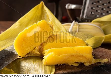 Pamonha, Brazilian Corn Food, Called Pamonha. On A Rustic Table With Knife And Old Corn Grater, Low