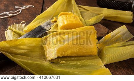 Pamonha, Brazilian Corn Food, Called Pamonha. On A Rustic Table With Knife And Old Corn Grater, Low