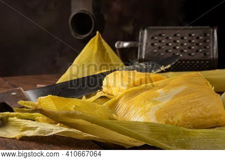Pamonha, Brazilian Corn Food, Called Pamonha. On A Rustic Table With Knife And Old Corn Grater, Low