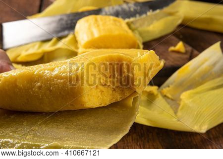 Pamonha, Brazilian Corn Food, Called Pamonha. On A Rustic Table With Knife And Old Corn Grater, Low