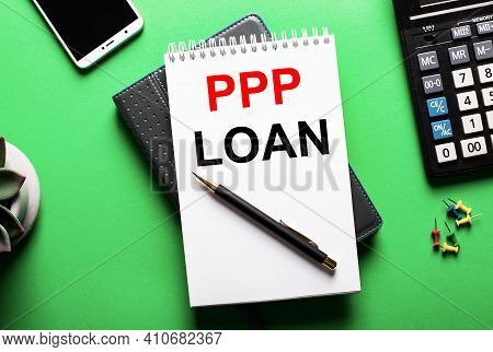 On A Green Background - A Telephone, A Calculator And A Diary With The Inscription Ppp Loan