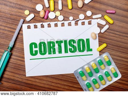 On A Wooden Table, A Syringe, Pills And A Sheet Of Paper With The Inscription Cortisol. Medical Conc