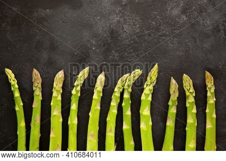 Bunch Of Asparagus Arranged In A Row On Dark Grey And White Background With Copy Space. Green Aspara