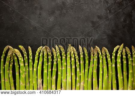 Bunch Of Asparagus Arranged In A Row On Dark Grey And White Background With Copy Space. Green Aspara