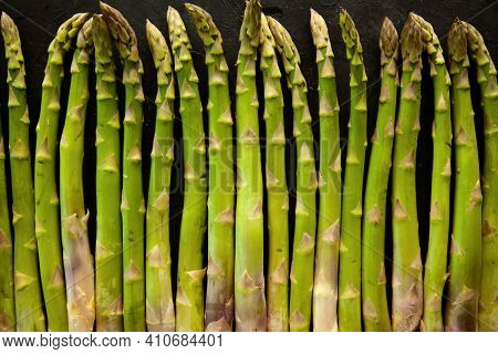 Bunch Of Asparagus Arranged In A Row On Dark Grey And White Background With Copy Space. Green Aspara