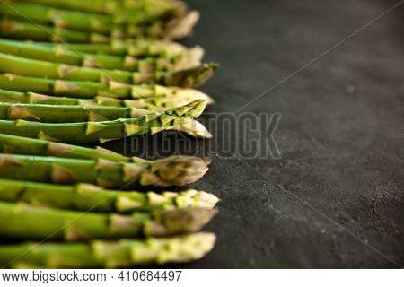 Bunch Of Asparagus Arranged In A Row On Dark Grey And White Background With Copy Space. Green Aspara