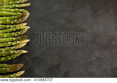 Bunch Of Asparagus Arranged In A Row On Dark Grey And White Background With Copy Space. Green Aspara