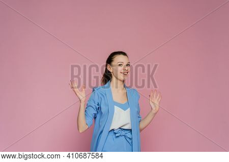 A Shoked Woman Is Shruging. A Woman Is Open-eyes On The Pink Background.