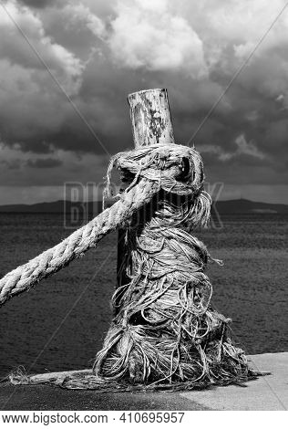 Rope On Seafront, Sea And Cloudy Sky In Sunny Summer Day. Black And White Toned Landscape. High Cont