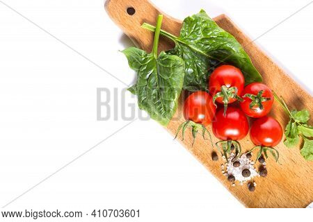 Cherry Tomatoes With Spinash And Other Herbs Prepared For Salad On Wooden Kitchen Board, With Copy S