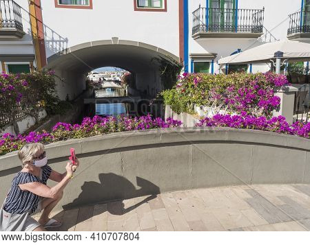 Puerto De Mogan, Gran Canaria, Canary Islands, Spain December 18, 2020: Senior Woman In Face Mask Ta
