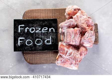 Frozen Raw Beef Bones On A Cutting Board. Frozen Food. Top View